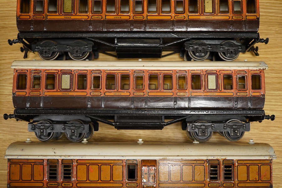 Three Carette for Bassett-Lowke 0 gauge railway 1921 series tinplate LSWR bogie coaches fitted with Bing couplings; two First Third Composite coaches, both 1328, and a full brake van, 133, all in salmon and chocolate liv